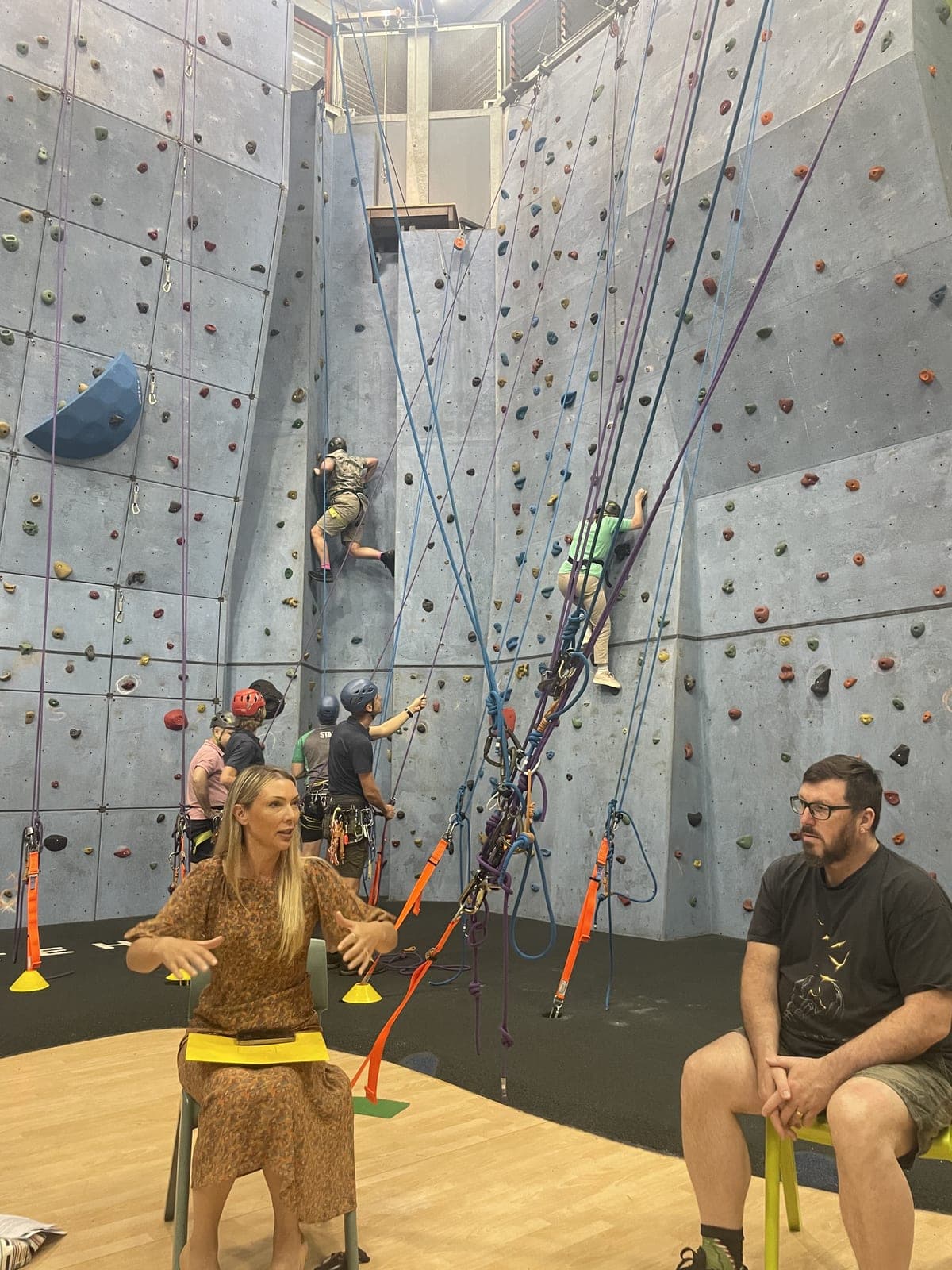 Climbers on the walls of the school's indoor climbing centre while parents look on from the floor